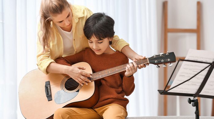 Private music teacher giving guitar lessons